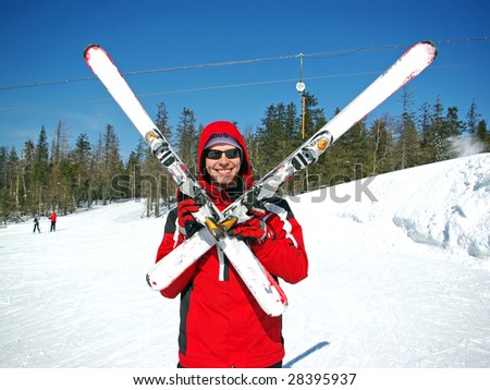 Skier standingwith crossed skis with a blue sky background