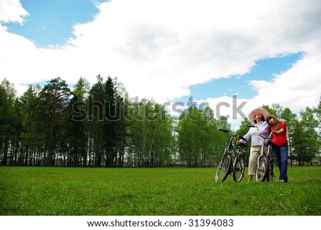 Grandmother and granddaughter with bicycles outdoors