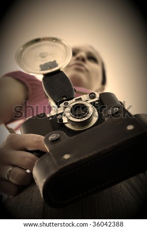 Young woman with old camera outdoor. Retro style.