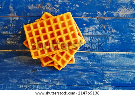 Top view showing golden squared waffles on a blue wooden table