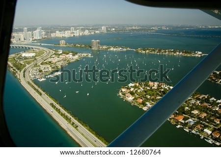 View of Miami from a little airplane showing the frame of the window and the support that holds the wing