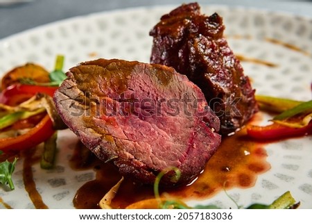 Roasted Beef fillet with vegetables. Roasted Mignon steak with paprika and celery. Beef tenderloin with garnish. Beef steak medium rare doneness. Delicious meat menu. Dish concept with angus beef