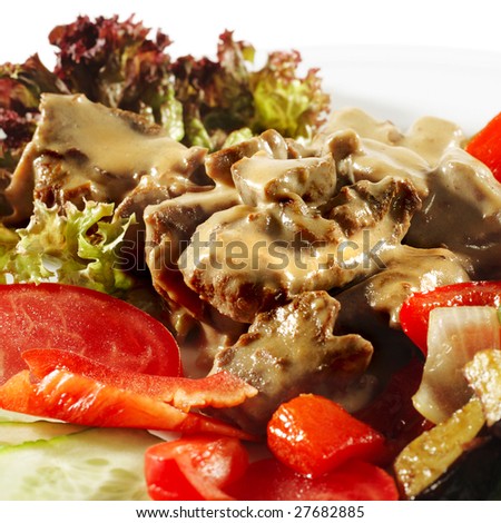 Hot Meat Dishes - Stewed Beef with Vegetables and Fresh Vegetable on Plate. Isolated on White Background
