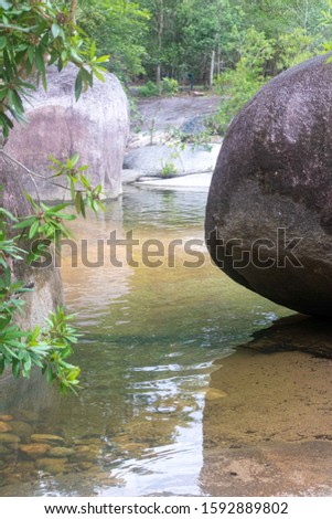Waterfall with a strong flood of water rocks below.Crystal clear water, huge stones with a beautiful vegetation around. At the end forming a strong current and later a calm lake with clean transparent