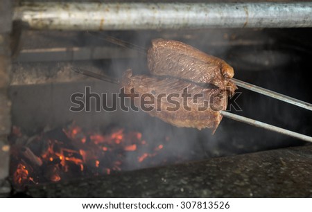 T-Bone Steak on Barbecue Grill Flames