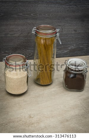 Food storage. Food ingredients in glass jars, on wood background.
