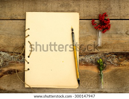 handmade notebook with old pen on a wooden background