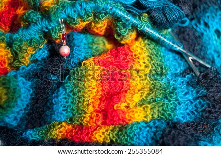 bright blue, yellow, red and green  knitted fabric texture with metal needles