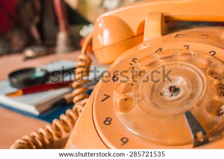 Old-style rotary phone numbers on table