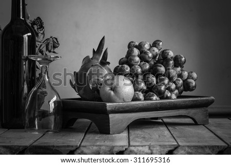 Fruit tray and a glass of wine with black and white.