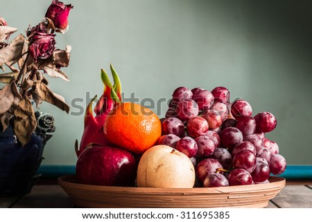 Fruit tray and a vase of flowers on the table.