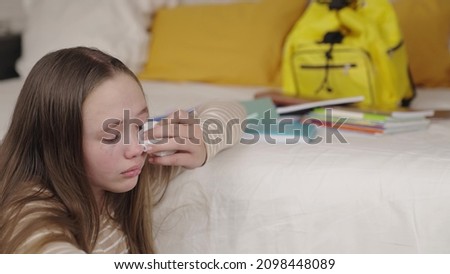 teenage girl crying wiping tears from wet eyes on her face, school difficulties upset child, resentment relationships with peers, psycho kid whims, sadness and loneliness with textbooks and backpack Photo stock © 
