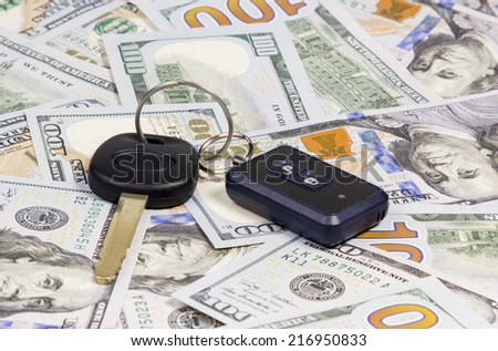 Car keys with remote control alarm located on the hundred dollar banknotes