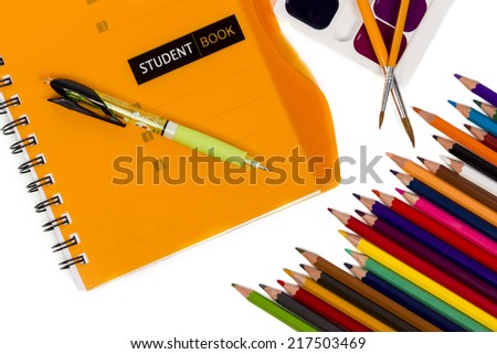 Still life consisting of notepad, pen, a set of paints and a set of pencils isolated on white background