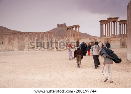 Palmyra, Syria- 28 November 2008: Visitors walking in the ancient city. Its Roman ruins are a UNESCO world heritage site. currently endangered due to regional military and political strife.