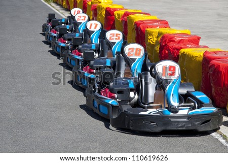 Carting-cars in a row in front of a barrier for background use