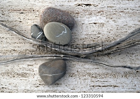 Still life photograph of weathered sticks and river stones.