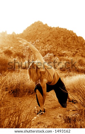 Senior woman practicing yoga during dusk in the desert.