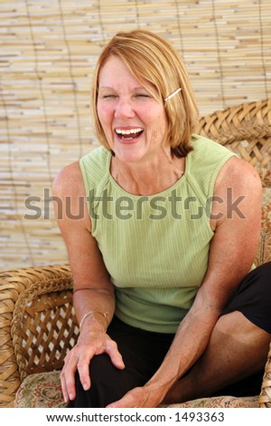 Natural senior woman laughing in a natural interior.