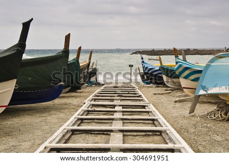 Beach with a boat and storm with threatening clouds coming from Mediterranean Sea, Italy
