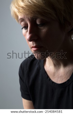 Sad blond woman in black clothes