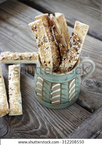 Puff pastry sticks with sesame seeds in a ceramic bowl