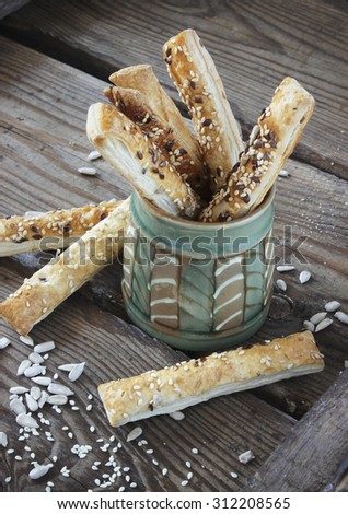 Puff pastry sticks with sesame seeds in a ceramic bowl