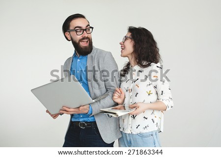 Young hipster man and woman in glasses with laptop and tablet isolated on the blank white background