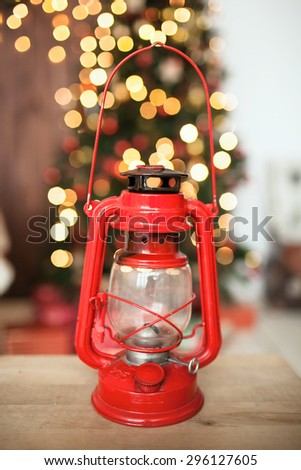 Red vintage oil lamp on the wooden floor in front of Christmas tree