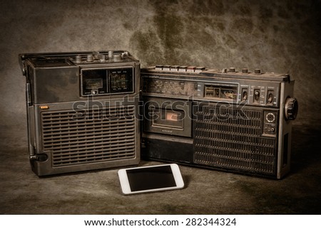the still life retro ghetto blaster and new smartphone on grunge background