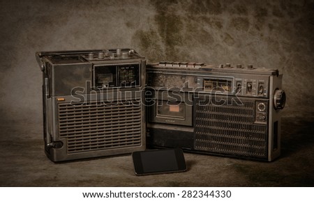 the still life retro ghetto blaster and new smartphone on grunge background