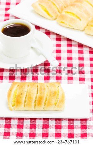 Coffee with gluten-free vanilla pastry on tablecloth white red squares