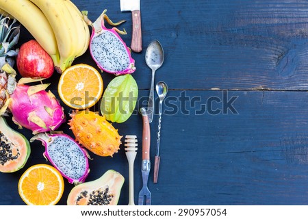 Tropical fruit on black wooden background, top view
