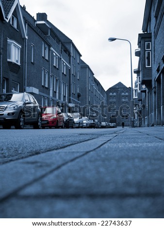 European street in monochrome color with an accent on red car.