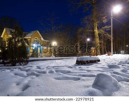 Light cottage in dark winter forest.