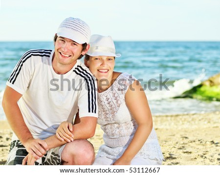 Smiling man and woman against a sea background