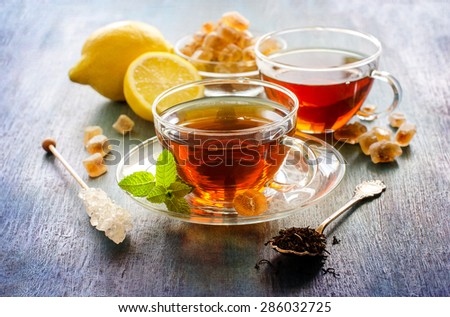 Cup of tea with mint and chrystal sugar on dark rustic background, hot drinks, teatime