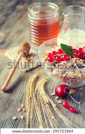 Healthy breakfast with muesli or granola, milk, fresh berries, red currant, crispbread, honey and wheat. Rolled oats, morning cereals, beauty diet concept