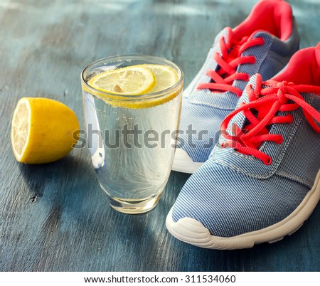 Sport concept, shoes for fitness, sneakers and glass of detox water with lemon, health and sport concept