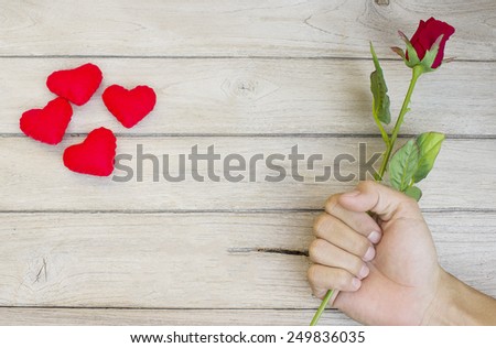 The feeling of love,Rose in hand and heart  on wood