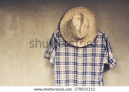 Vintage,weave hat and plaid shirt on the wall