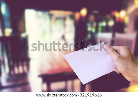 hands holding paper  with Coffee shop blur background