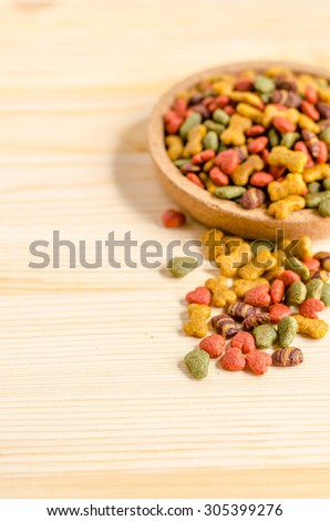 Dry dog food in wooden dish and wooden background