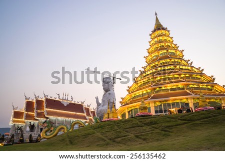 Guan Yim giant statue with Thai temple church and dragon stairs in Thai temple under twilight sky