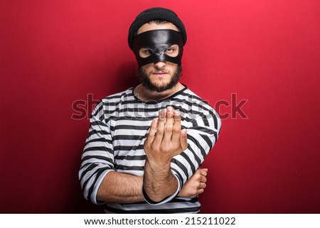 Angry criminal inviting with hand on red background