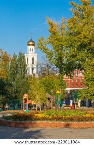 Connecting the past and the future.  Modern playground for children situated near ancient bell tower and old theatre building.  Samara. Russia.