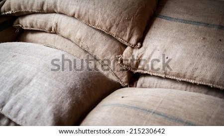 Full frame detail from within a warehouse packaging their goods in hessian sacks.