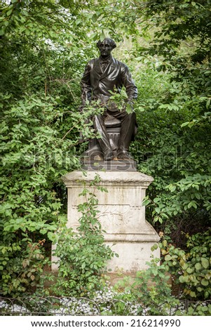 LONDON, UK - MAY 9, 2006: A statue of the British philosopher and economist John Stuart Mill buried away amongst the foliage of Victoria Embankment Gardens, a public park close to Westminster Bridge.