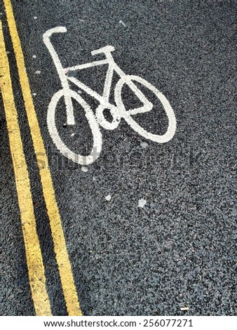 UK bicycle lane markings on a freshly laid black tarmac road with double yellow lines (no parking) and copy space.