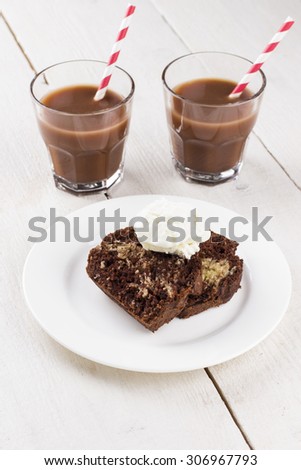Chocolate and vanilla cake with ice cream and cocoa drink on a white wooden background